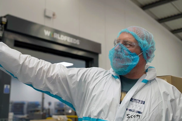 Factory worker wearing protective gear during a compliance inspection.