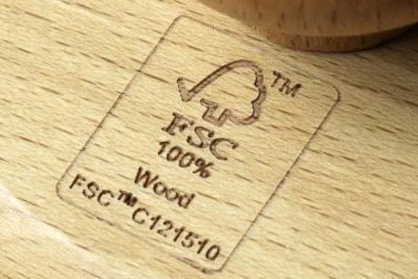 FSC 100% wood certification mark engraved on a light wood surface.