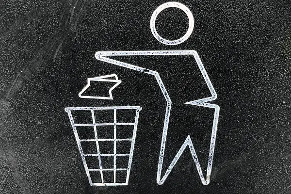Illustration of a person disposing of waste into a bin, symbolizing product end-of-life.