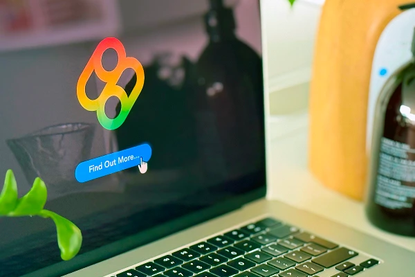 Close-up of a laptop displaying the Bombiix logo with a “Find Out More…” button on screen.