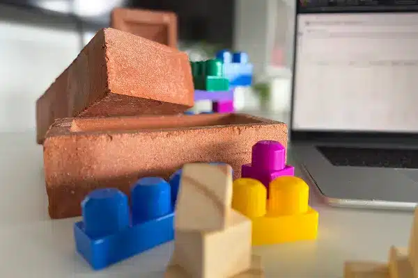 Colorful toy blocks and bricks next to a laptop, symbolizing system modularity and configurability.