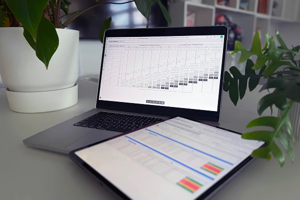 Laptop and tablet displaying quality control and module tracking dashboards in Bombiix software.
