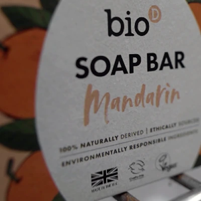Close-up of Bio D Mandarin soap bar packaging emphasizing sustainability and ethical sourcing.