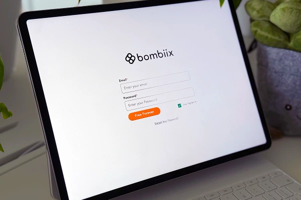 Tablet screen displaying Bombiix login interface with 'Free Forever' account option.