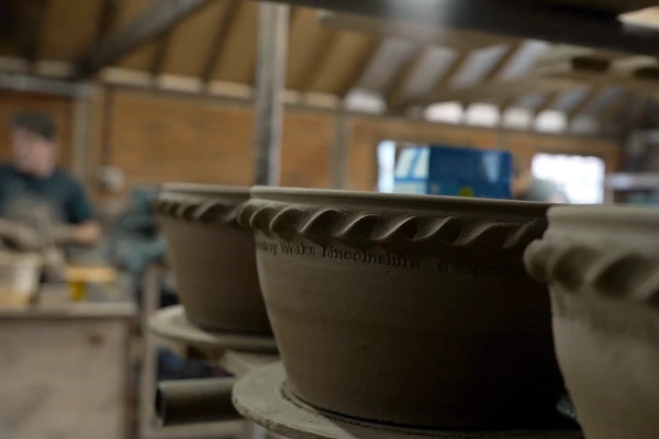 Close-up of handcrafted ceramic pots in a pottery workshop.
