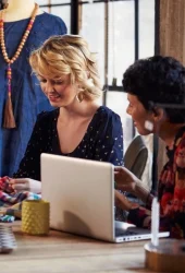 Two buyers in a meeting sat at a laptop talking about product development